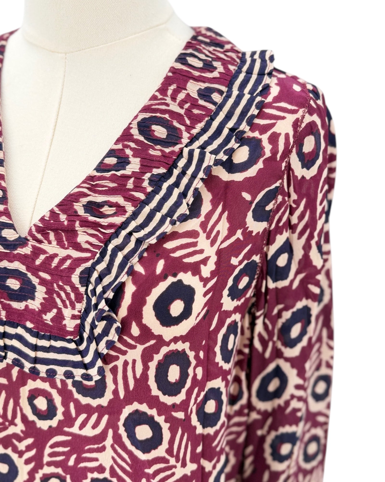 Mannequin wearing a patterned blouse with a deep neckline.