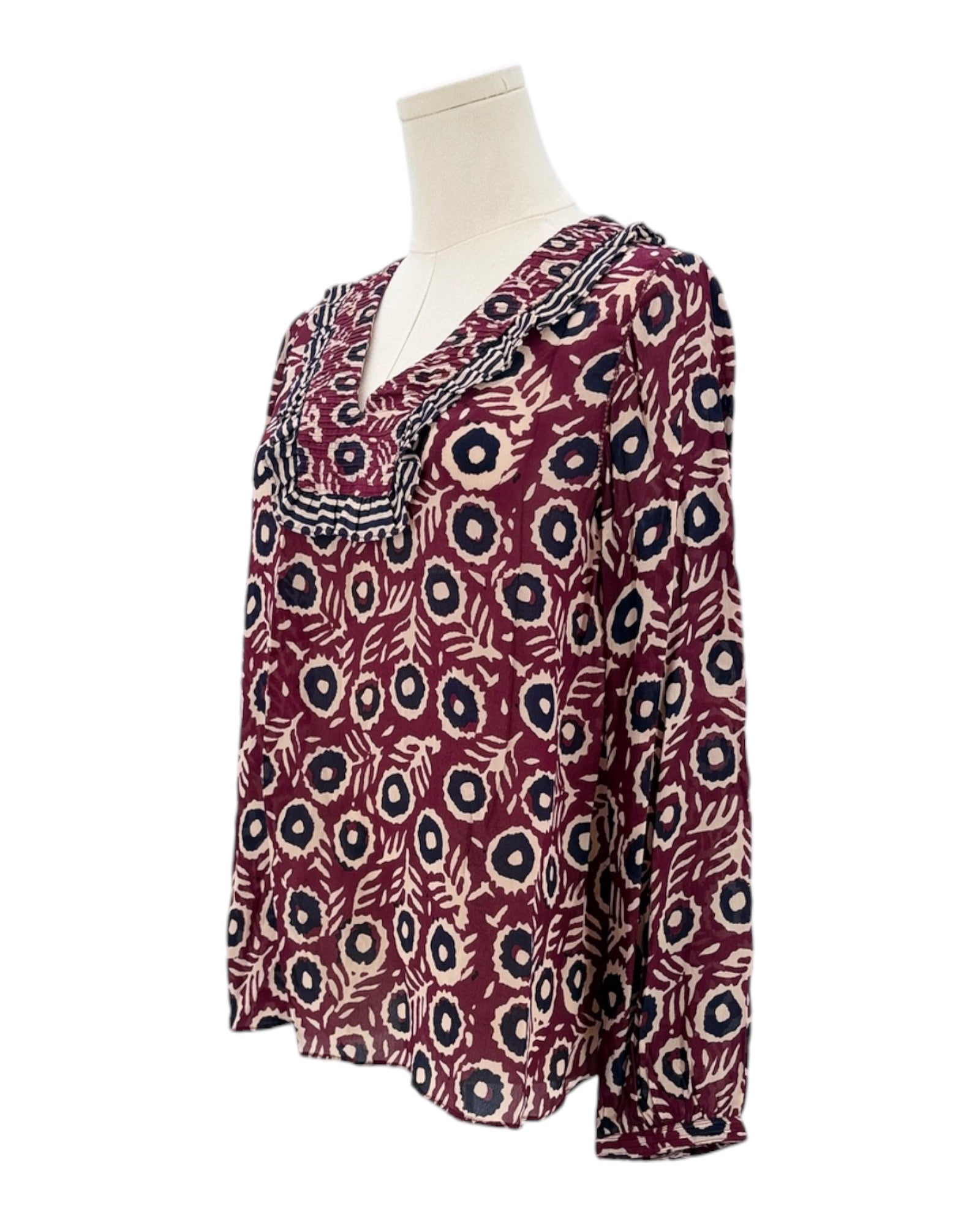Patterned blouse on a mannequin against a white background