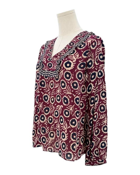 Patterned blouse on a mannequin against a white background