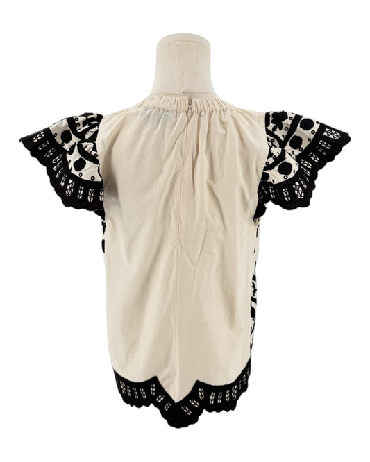 Cream with black applique throughout, flutter sleeves, scalloped hemline, elastic neckline on a white background on a mannequin