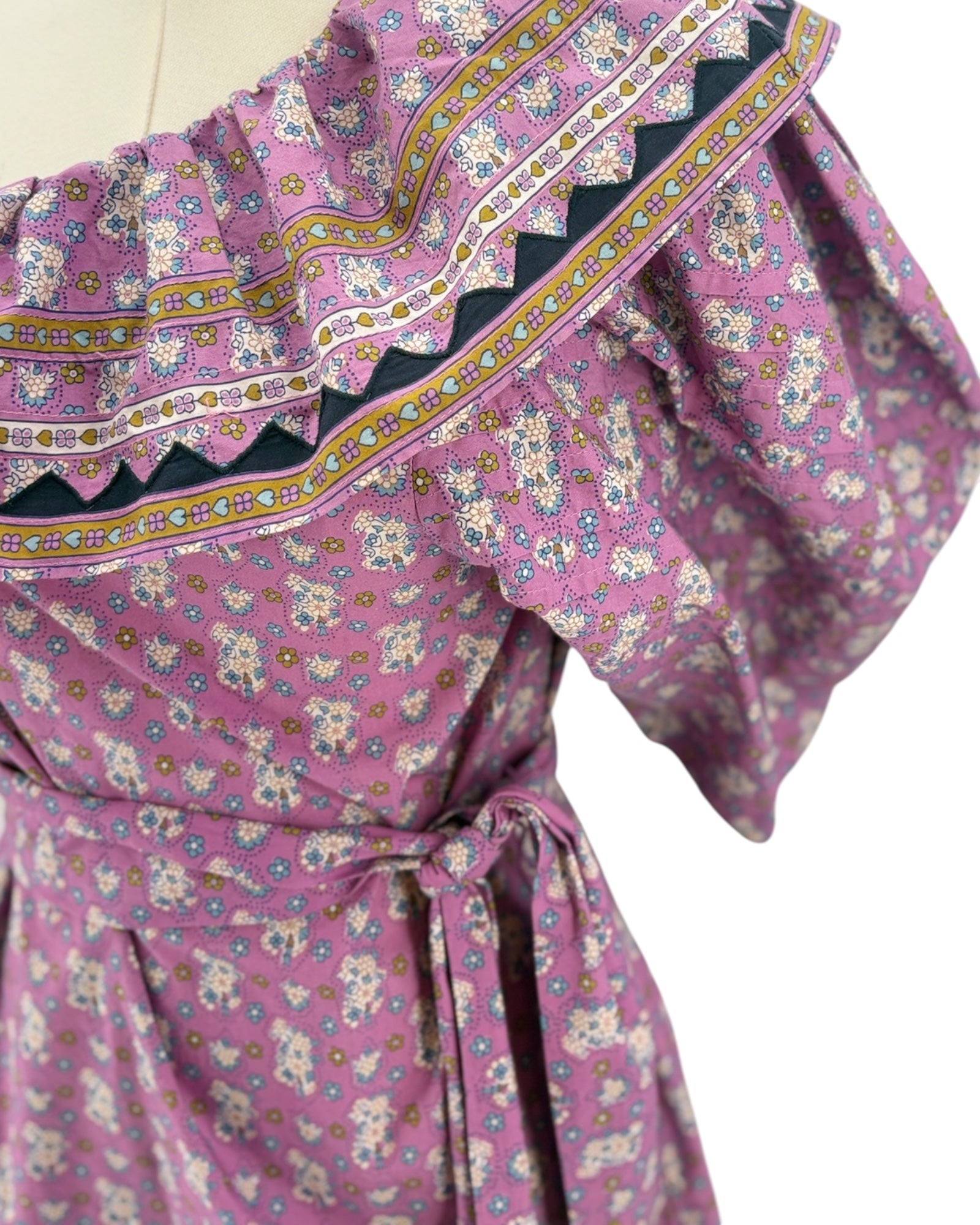 Pink floral dress with ruffled details on a white background
