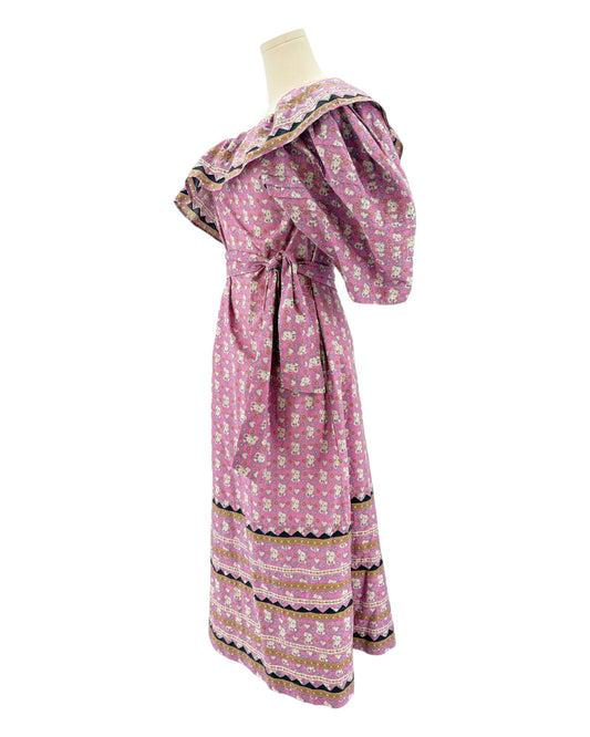 Pink floral dress on a mannequin against a white background