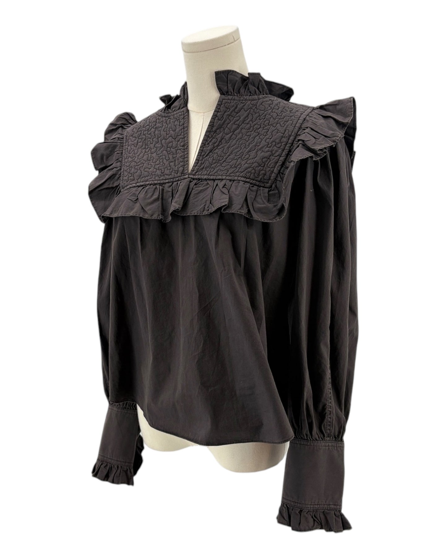 Dark gray blouse with ruffled details on a mannequin against a white background