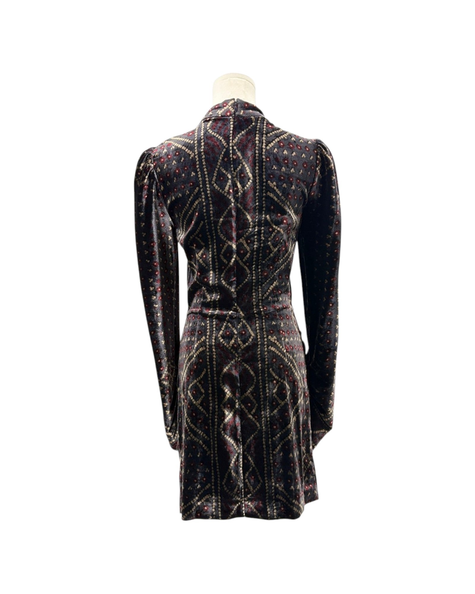 A long-sleeve velvet mini dress shown from the back on a mannequin, featuring a dark base with intricate geometric patterns in gold, red, and blue.