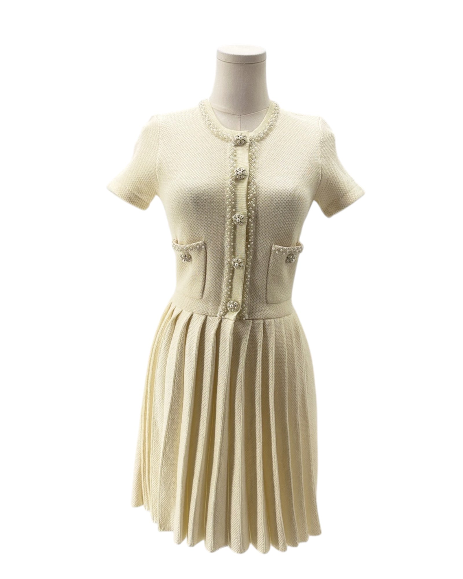 Mannequin wearing a cream-colored dress with a patterned cardigan on a white background