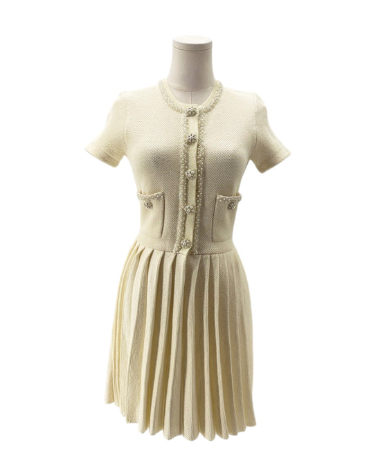 Mannequin wearing a cream-colored dress with a patterned cardigan on a white background
