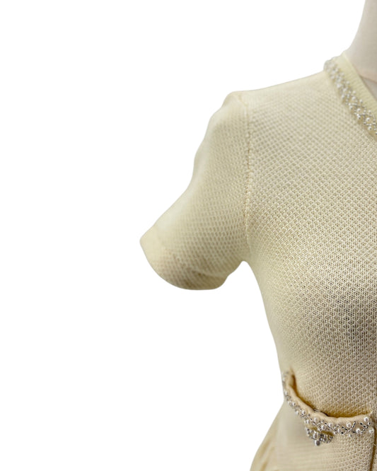 Beige knitted dress with a belt on a mannequin against a white background