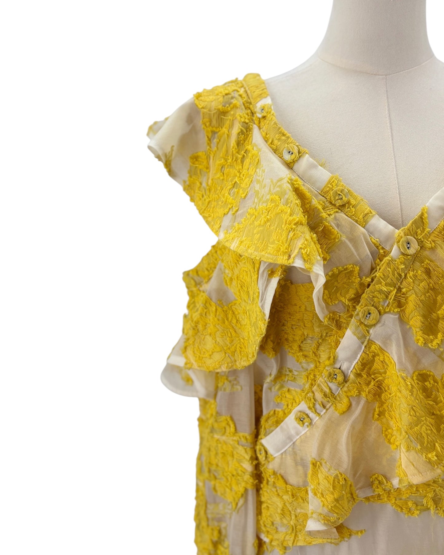 Yellow lace top on a mannequin against a white background