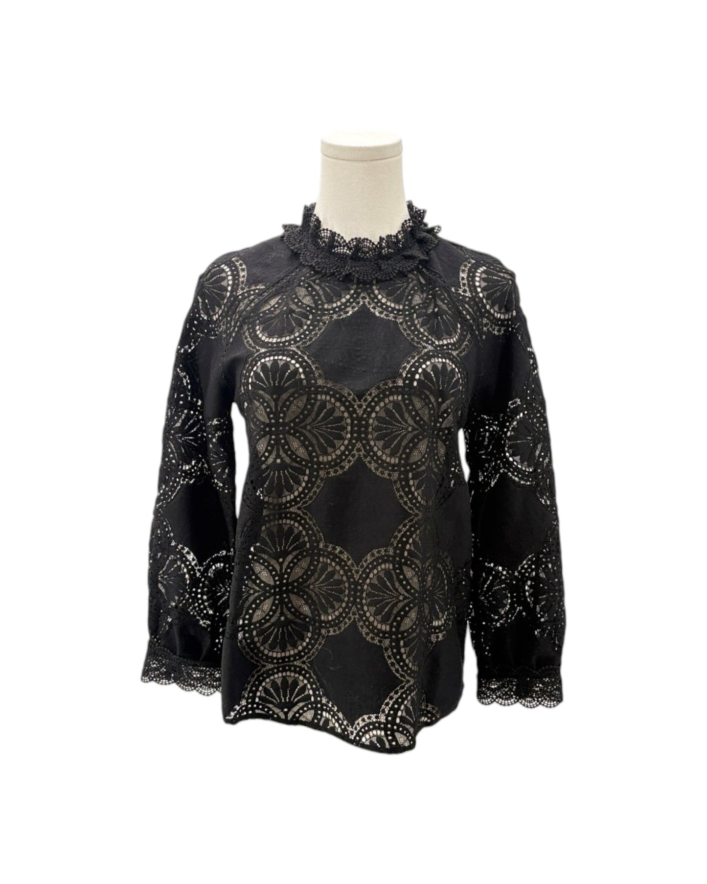 A black long-sleeve blouse with an intricate circular lace overlay pattern, displayed on a mannequin torso against a plain white background.