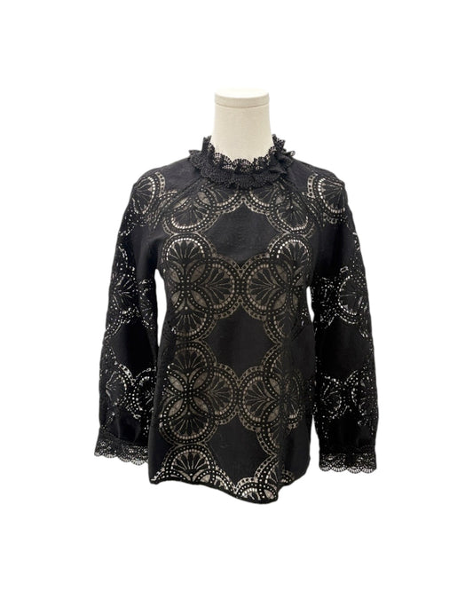 A black long-sleeve blouse with an intricate circular lace overlay pattern, displayed on a mannequin torso against a plain white background.