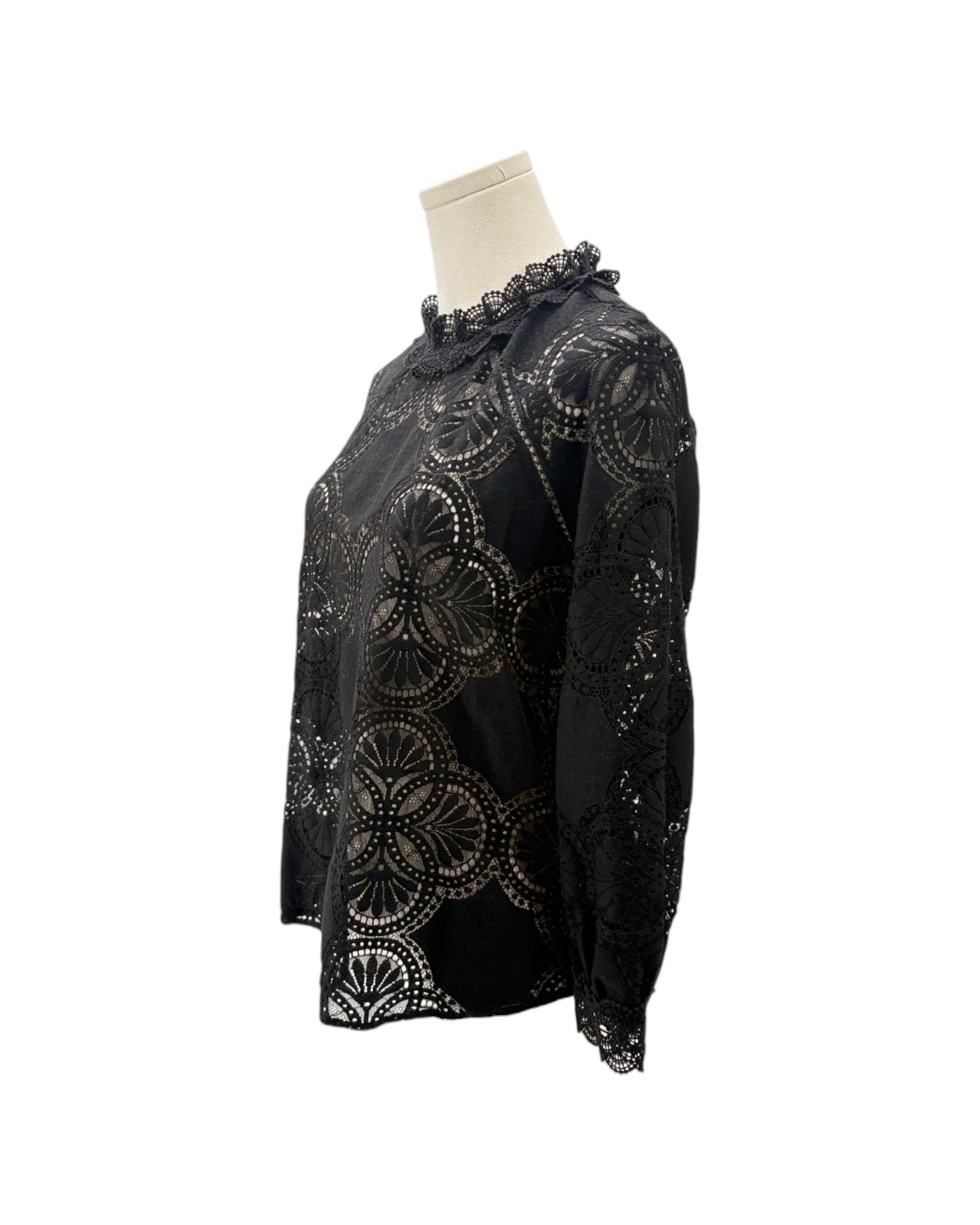 A black long-sleeve blouse with intricate circular cutwork embroidery, displayed on a cream mannequin torso against a plain white background.