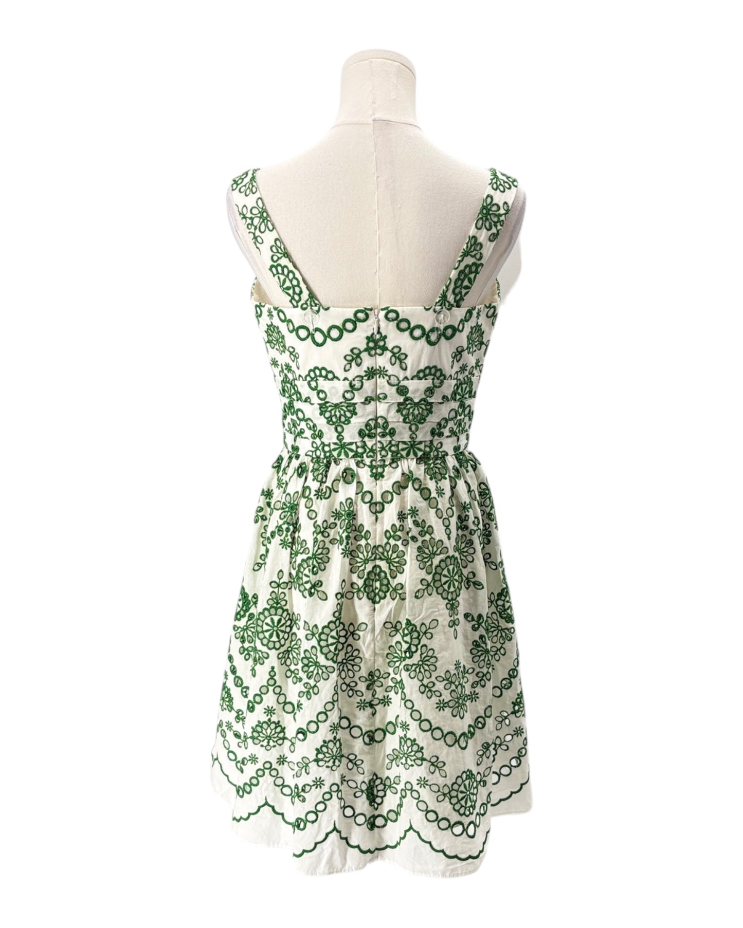 Green and white floral dress on a mannequin against a white background