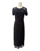 Black lace dress on a mannequin against a white background
