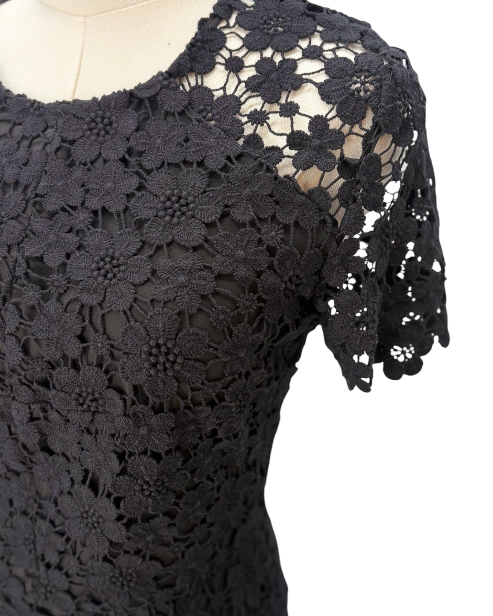 Black lace dress on a mannequin with a white background