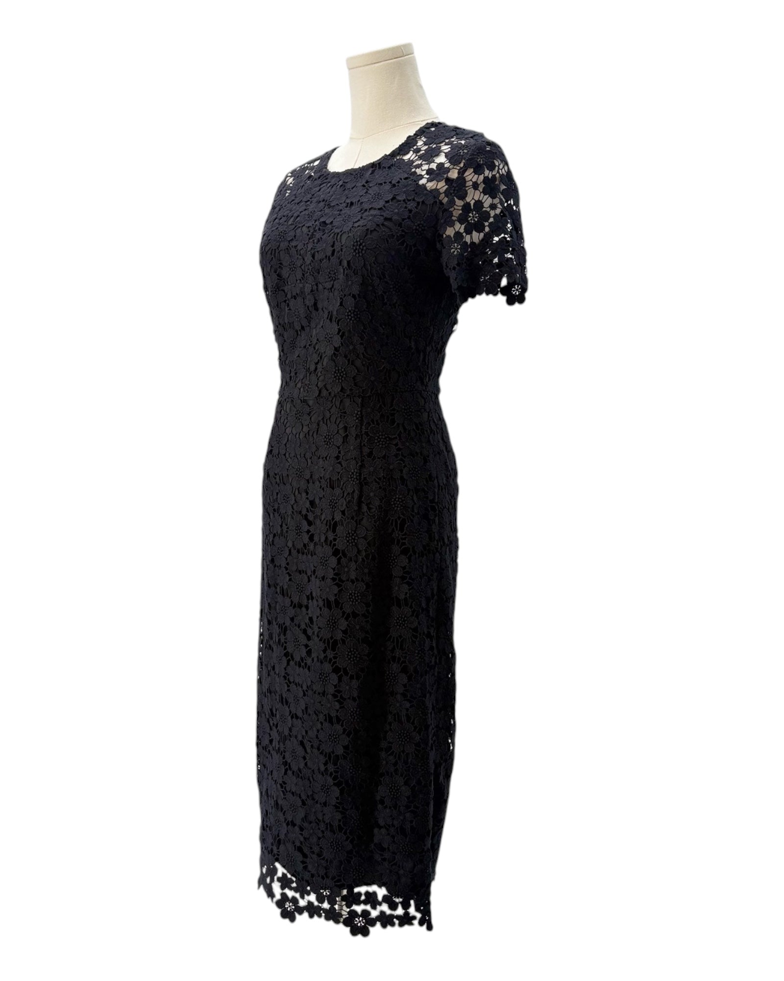 Black lace dress on a mannequin against a white background