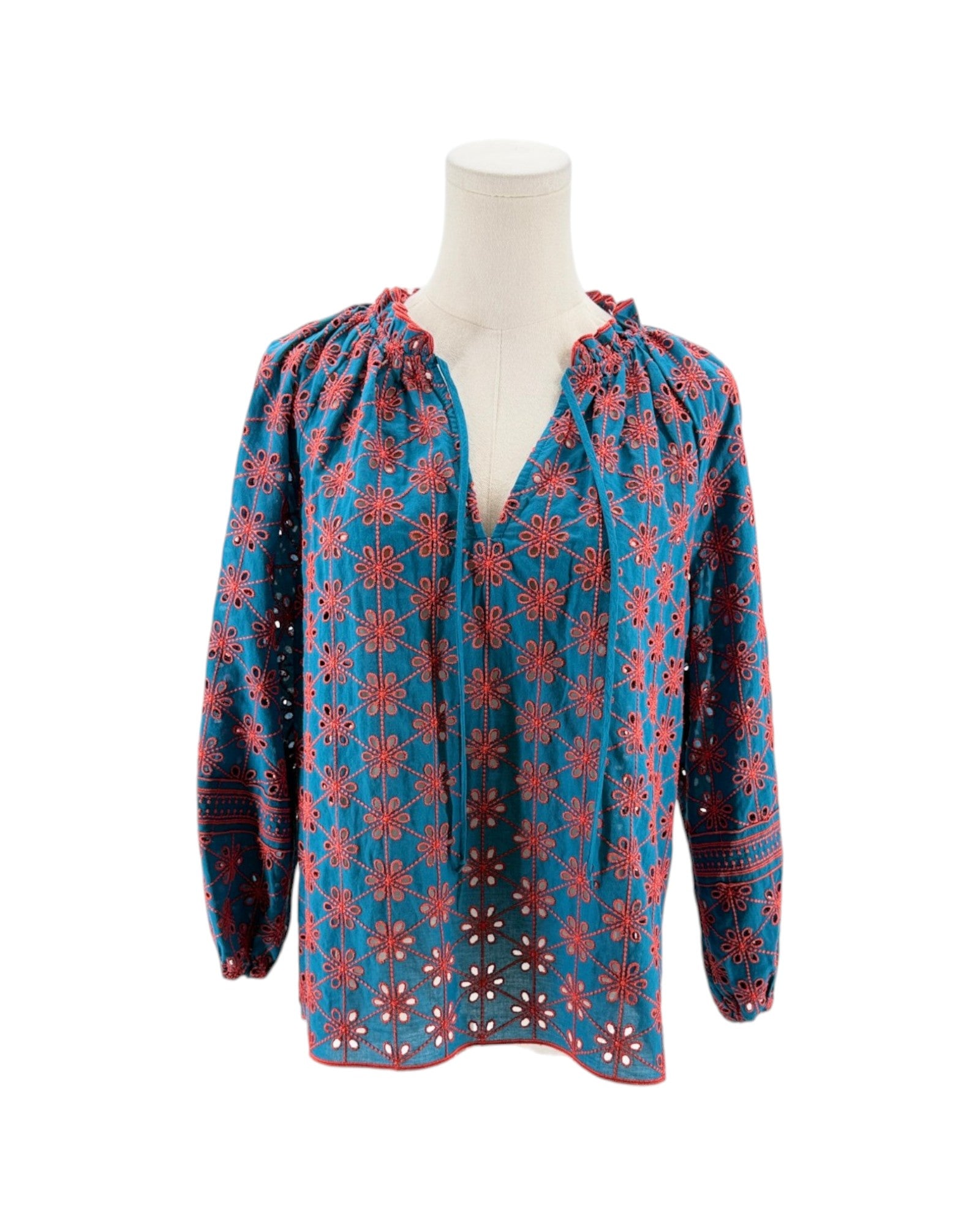 Blue blouse with red floral pattern on a mannequin against a white background