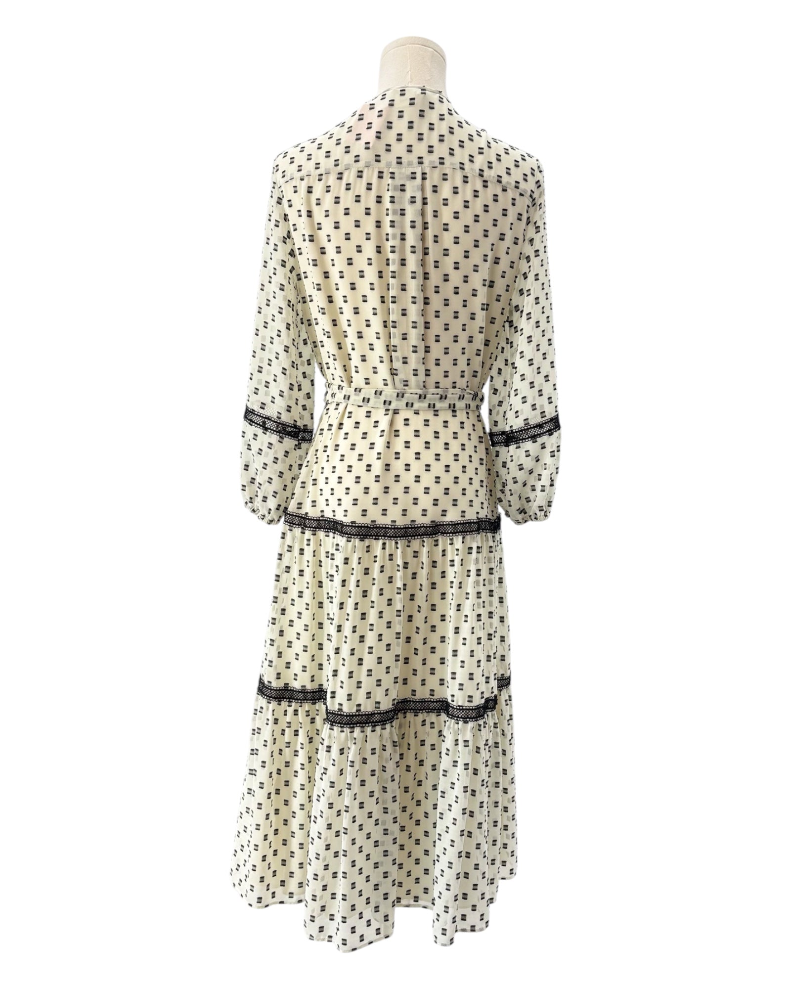 White dress with black print on a mannequin against a white background