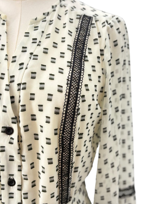 White dress with black pattern and lace trim on a white background