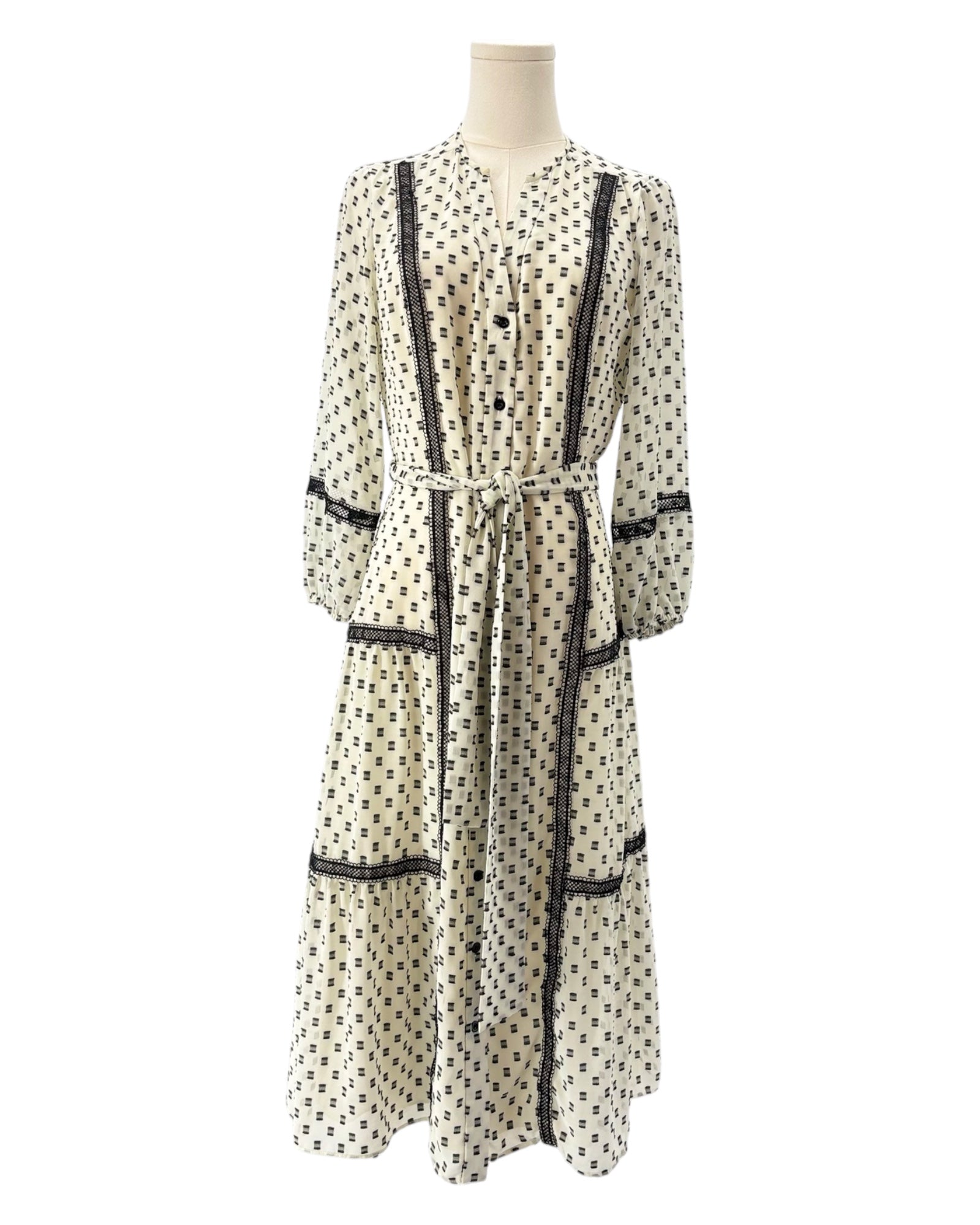 Printed dress with black accents on a mannequin against a white background