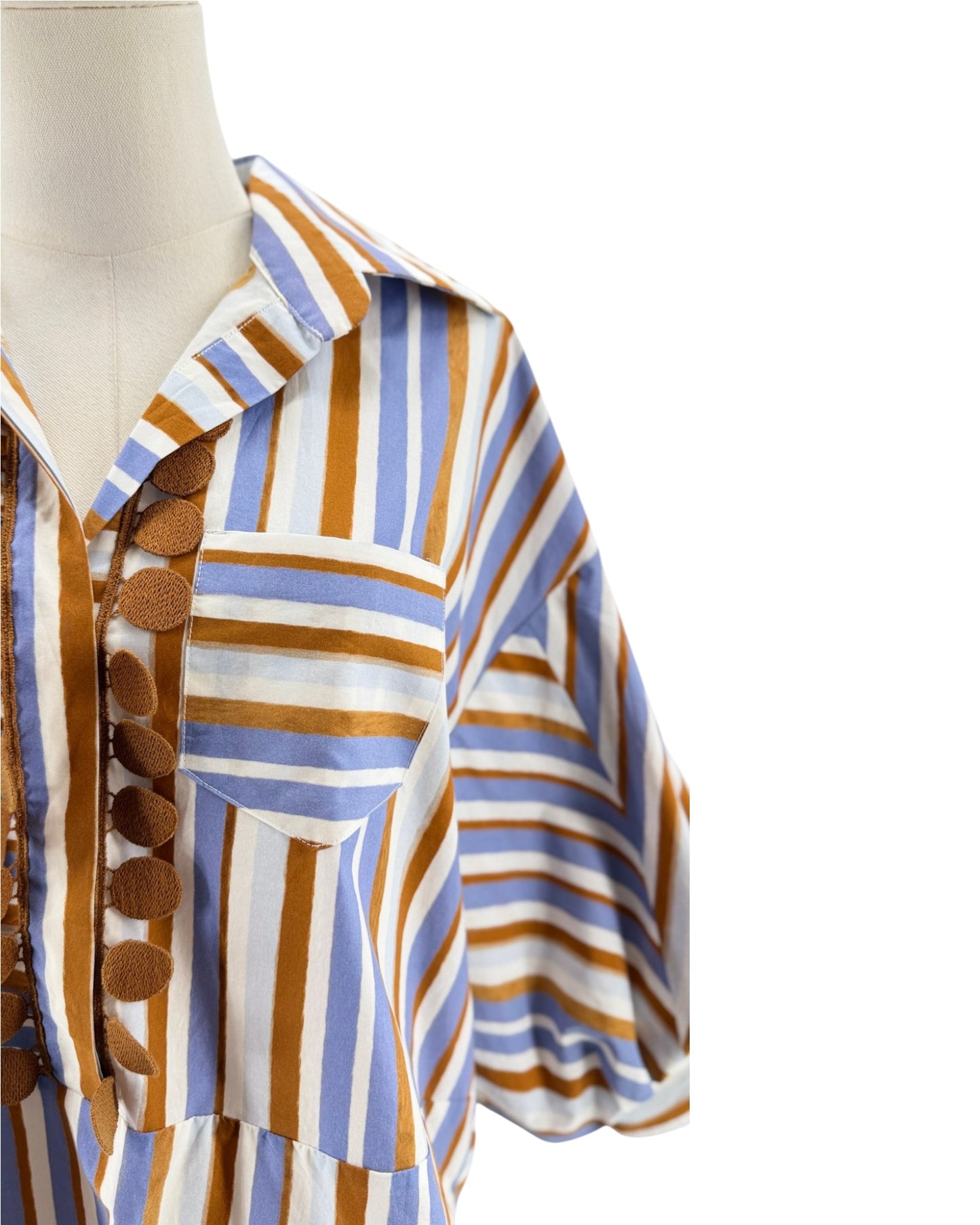Mannequin wearing a colorful striped shirt with brown, blue, and white pattern on a white background