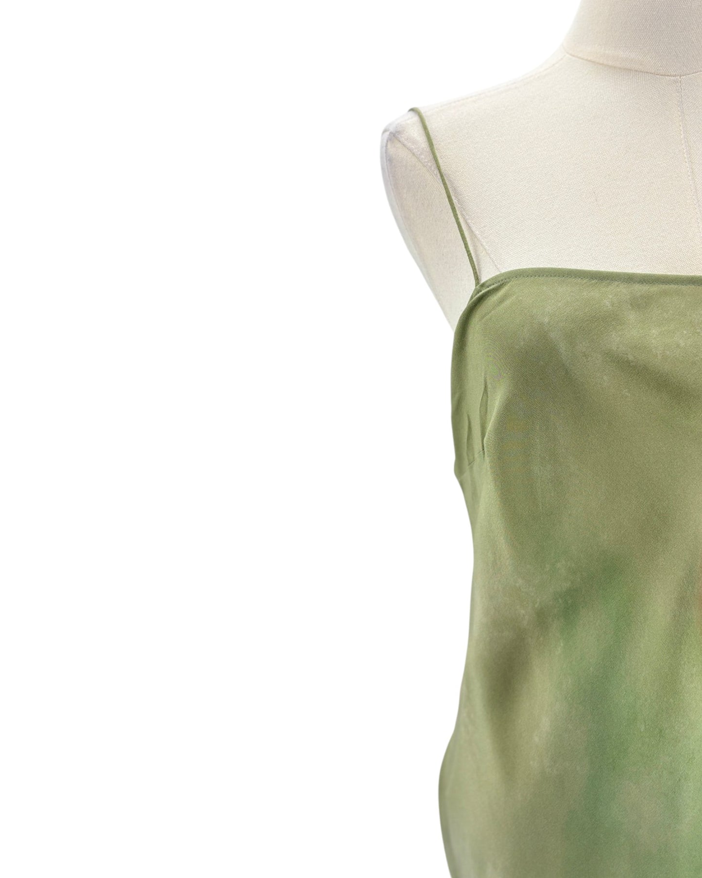 Green dress on a mannequin against a white background