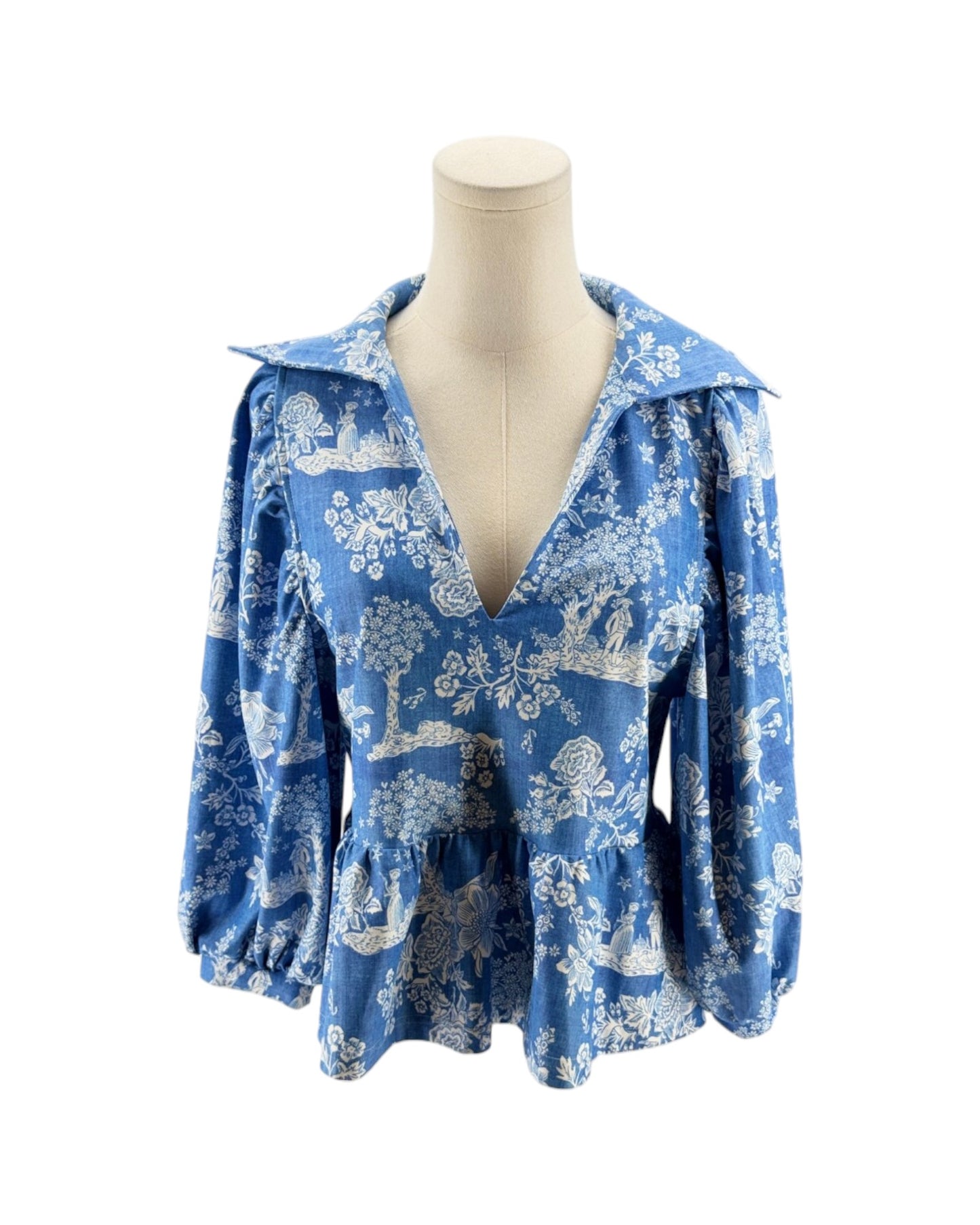 Blue floral blouse on a mannequin against a white background