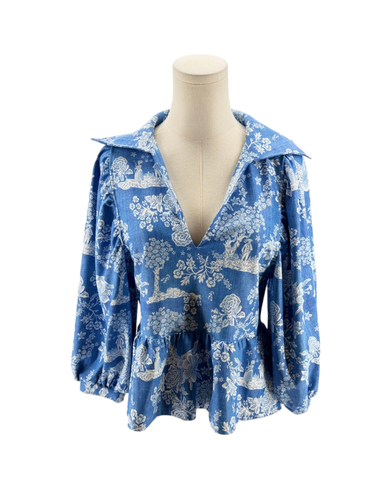 Blue floral blouse on a mannequin against a white background