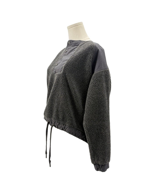 A dark gray cropped fleece pullover sweater with a contrasting solid dark gray collar and button placket, shown on a mannequin torso against a white background.