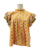 Colorful patterned blouse on a mannequin against a white background