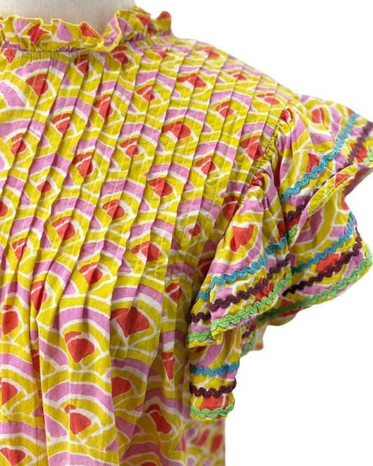Colorful patterned top with ruffled edges on a white background