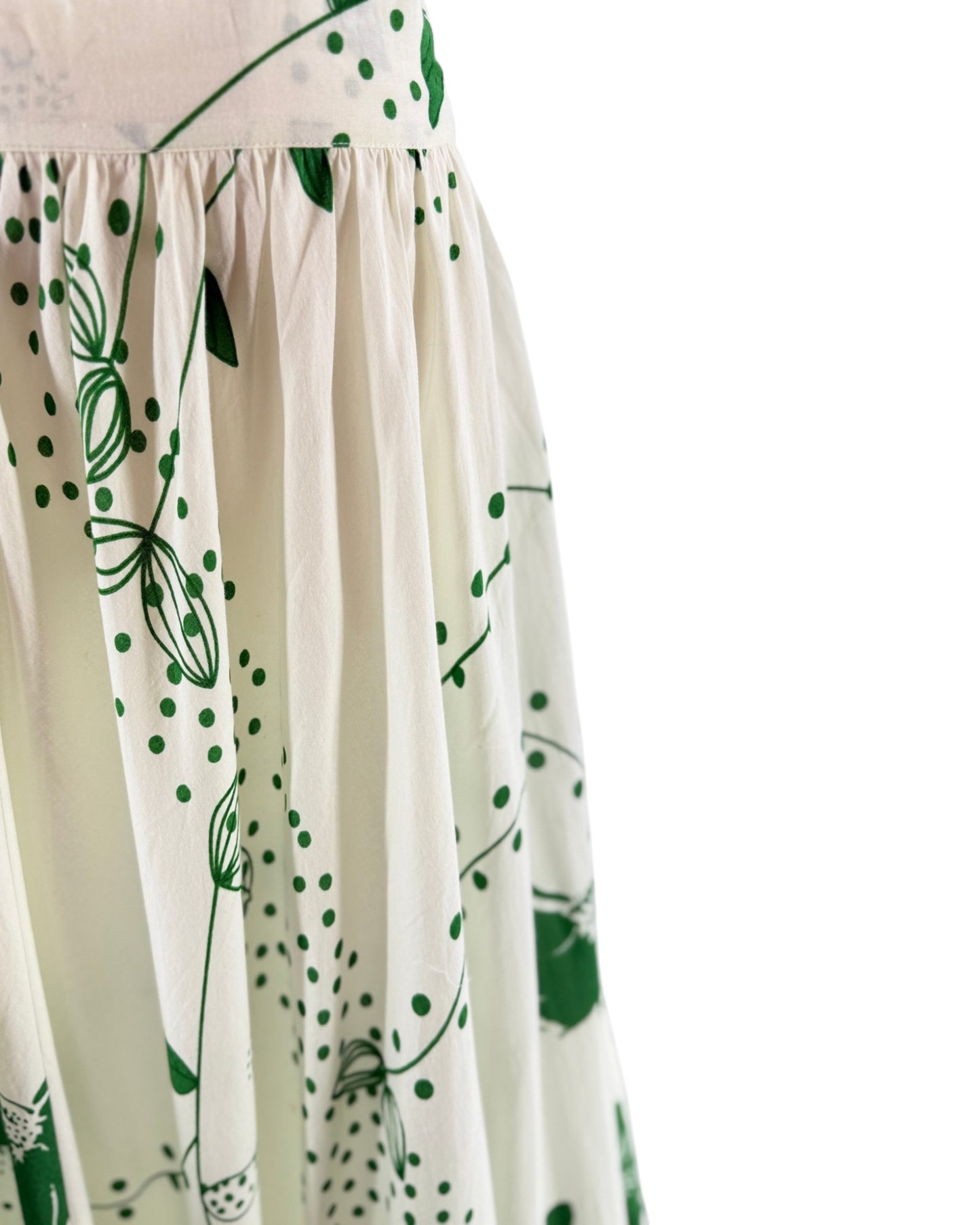 White dress with green floral patterns on a white background