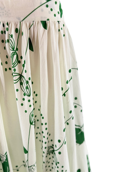White dress with green floral patterns on a white background