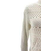 Close-up of a white crochet sweater on a white background