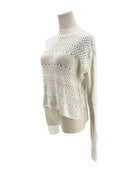 White textured sweater on a mannequin against a white background