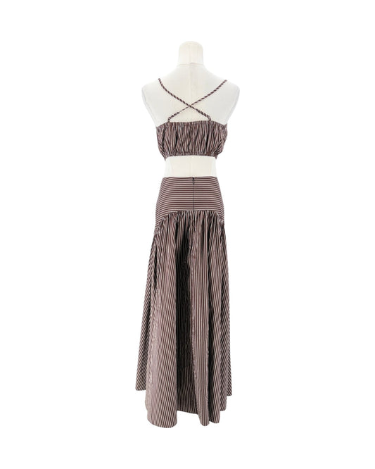 A two-piece two-tone striped maxi dress displayed on a mannequin against a white background. The dress features a brown and white vertically striped crop top with criss-cross straps and a matching high-waisted, gathered maxi skirt.