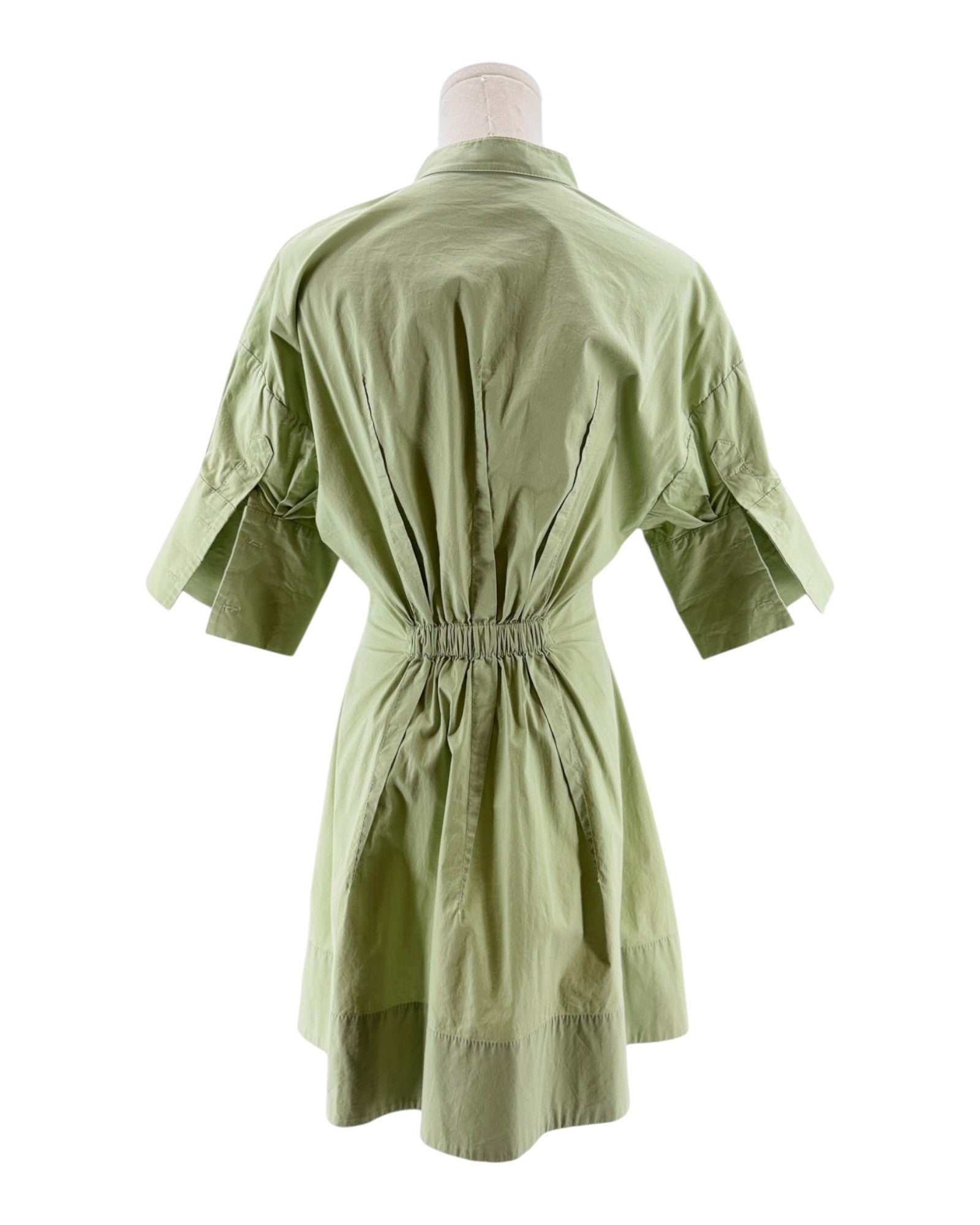 Green dress on a mannequin against a white background