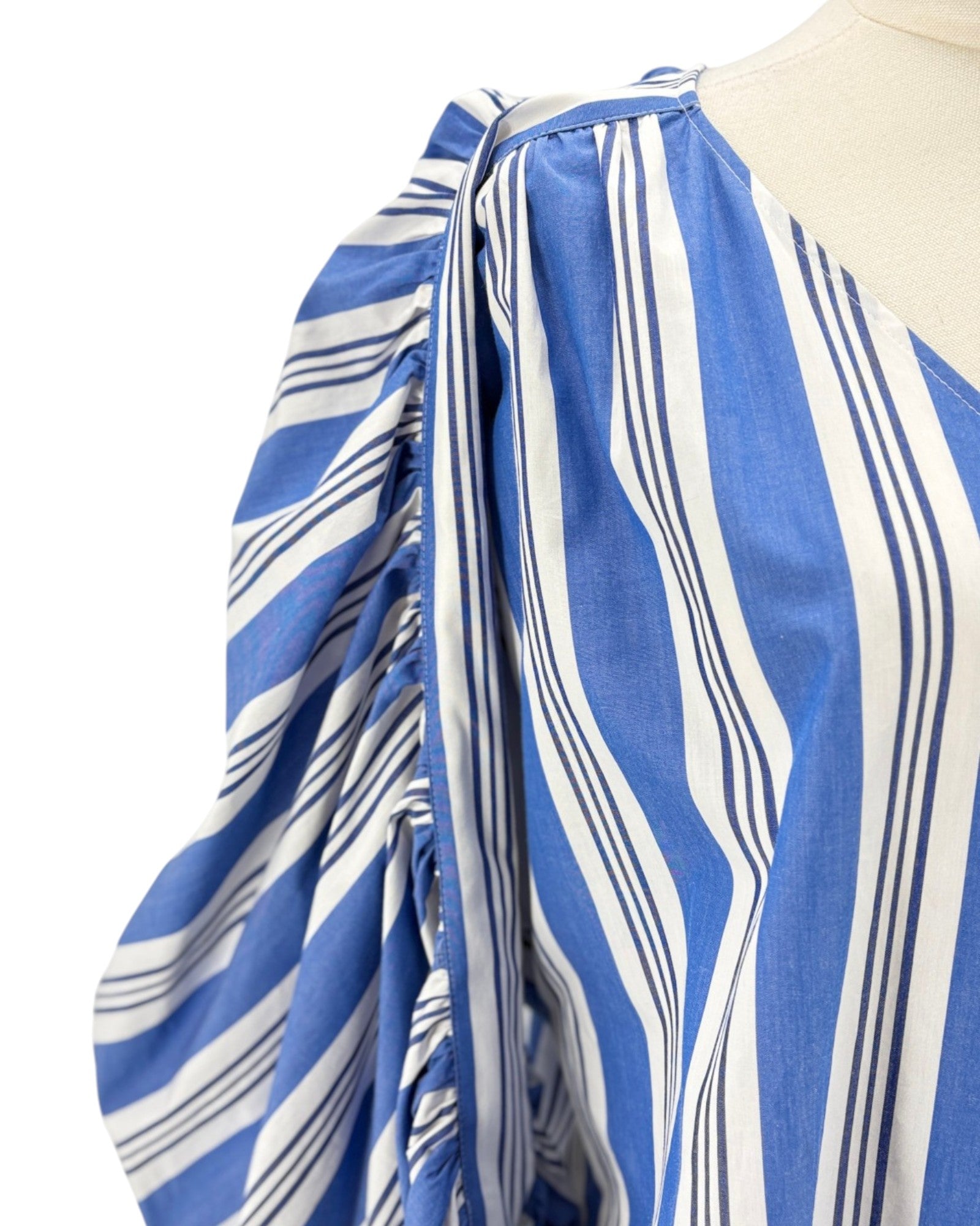 Blue and white striped dress on a mannequin with a plain background