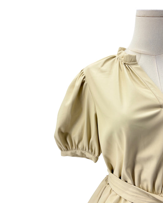 Beige dress with puff sleeves on a mannequin against a white background