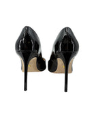 Pair of black patent high-heeled shoes on a white background