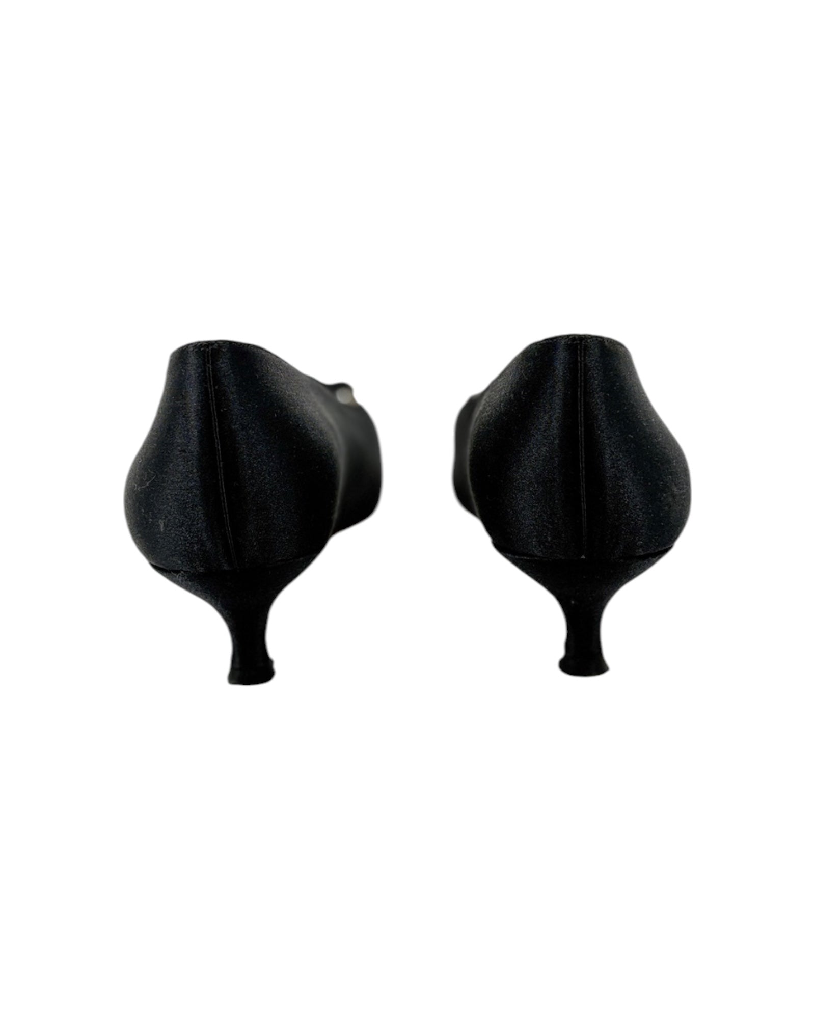 Pair of black high-heeled shoes with bow details on a white background
