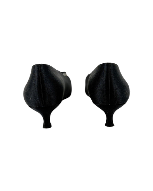 Pair of black high-heeled shoes with bow details on a white background