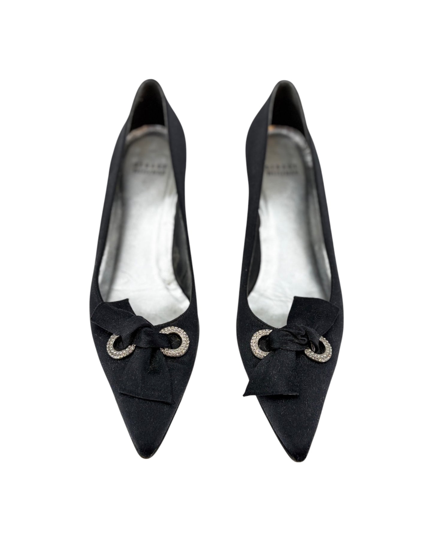 Pair of black high-heeled shoes with bow details on a white background