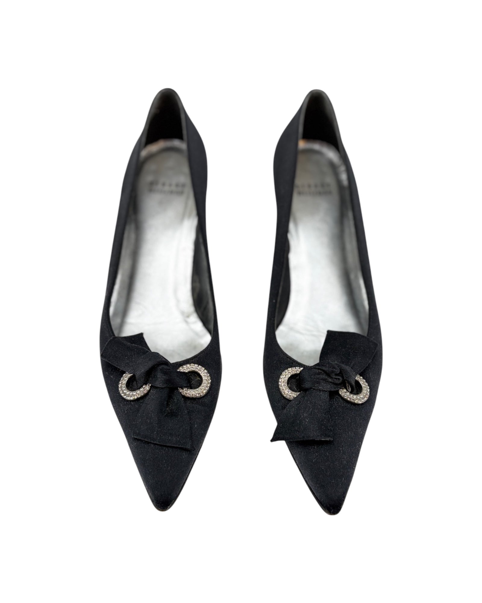 Pair of black high-heeled shoes with bow details on a white background