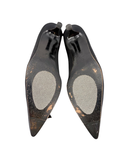 Pair of black high-heeled shoes with pointed toes on a white background
