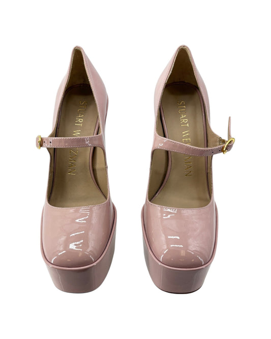 Pair of pink platform shoes with a strap on a white background