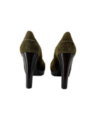 Pair of green suede high-heeled shoes on a white background