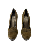 Pair of olive green suede shoes on a white background