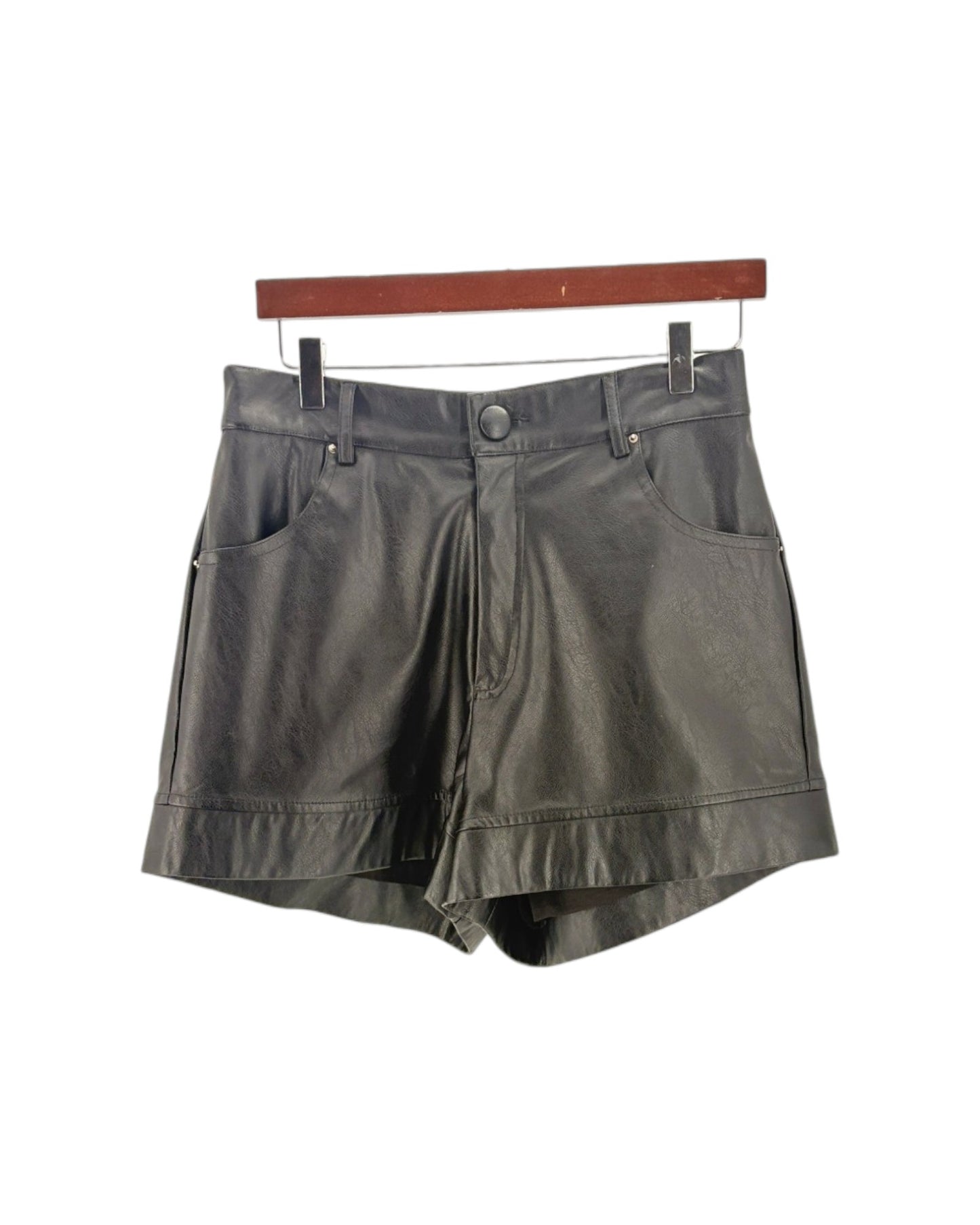 Black shorts on a hanger against a white background