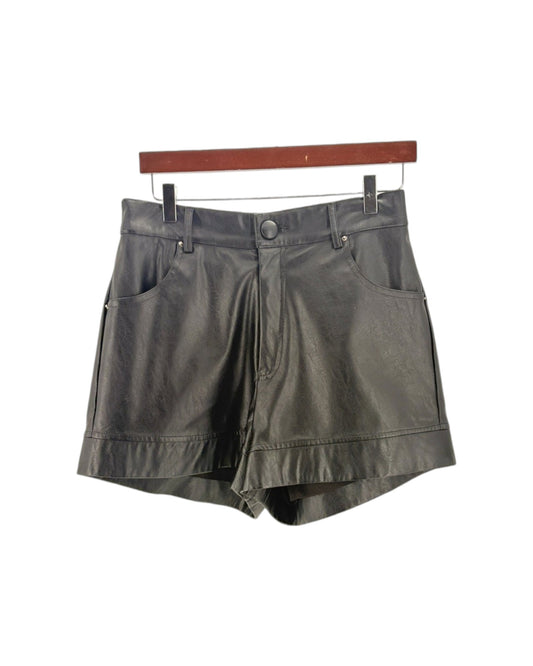Black shorts on a hanger against a white background