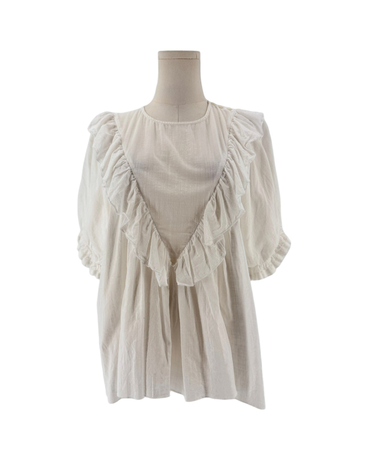 White ruffle triangle top, v-shaped ruffle down the body, voluminous short sleeves, round neckline on a mannequin on a white background